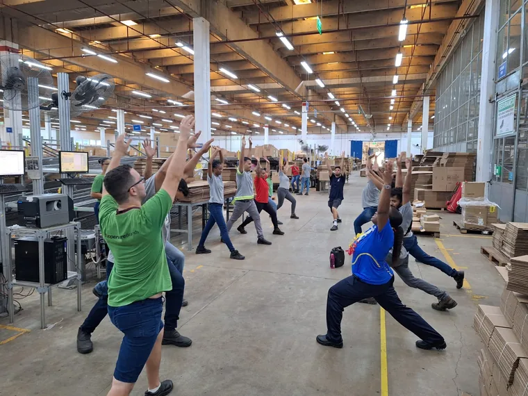 Sessão de ginástica laboral com colaboradores em um centro de distribuição